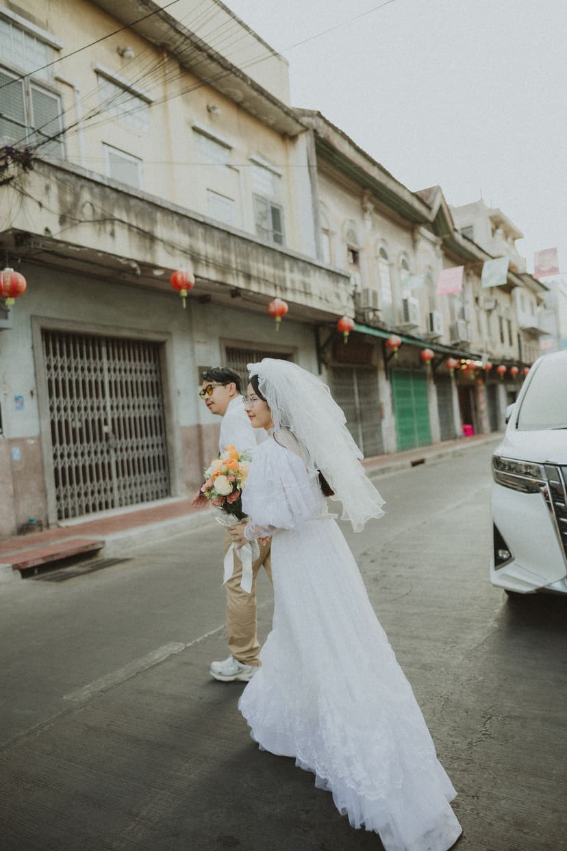 The bride walking Songwat Road, veil streaming behind