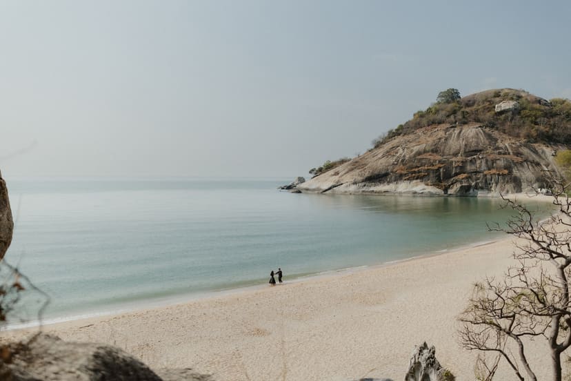 A wide turquoise bay with the couple tiny in the frame